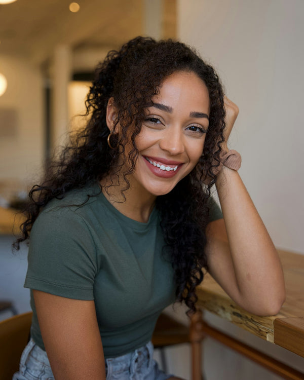 Trichologie - femme souriante aux cheveux bouclés