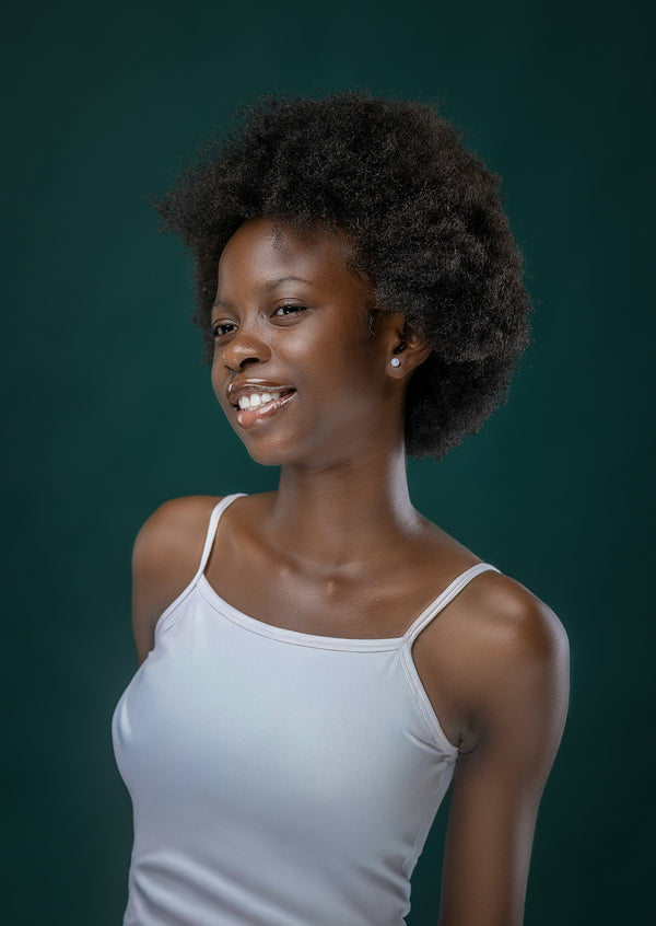 Trichologie - jeune femme souriante aux cheveux crépus