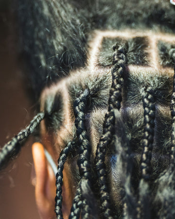 Tight box braids with visible partings on the scalp
